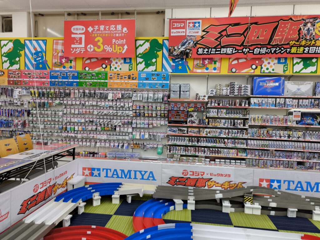 コジマ×ビックカメラ所沢店のミニ四駆パーツ売り場の棚。ベアリングローラーやマスダンパーなど多種多様なパーツが陳列されている。