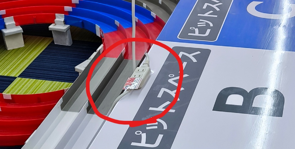 コジマ×ビックカメラ所沢店のミニ四駆ピットスペースB卓の脇に設置された電源タップのクローズアップ。