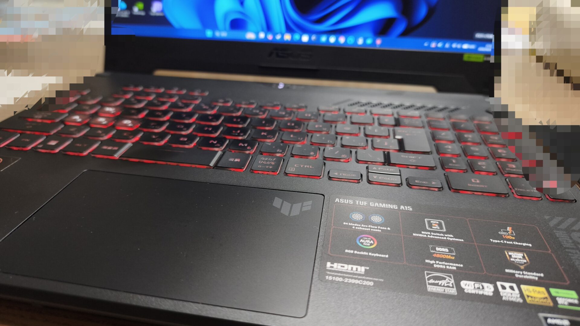 ぼくが実際に使っているゲーミングノート ASUS TUF Gaming A15。赤く光るキーボードと、DDR5やMUX Switchが並ぶスペックのシール