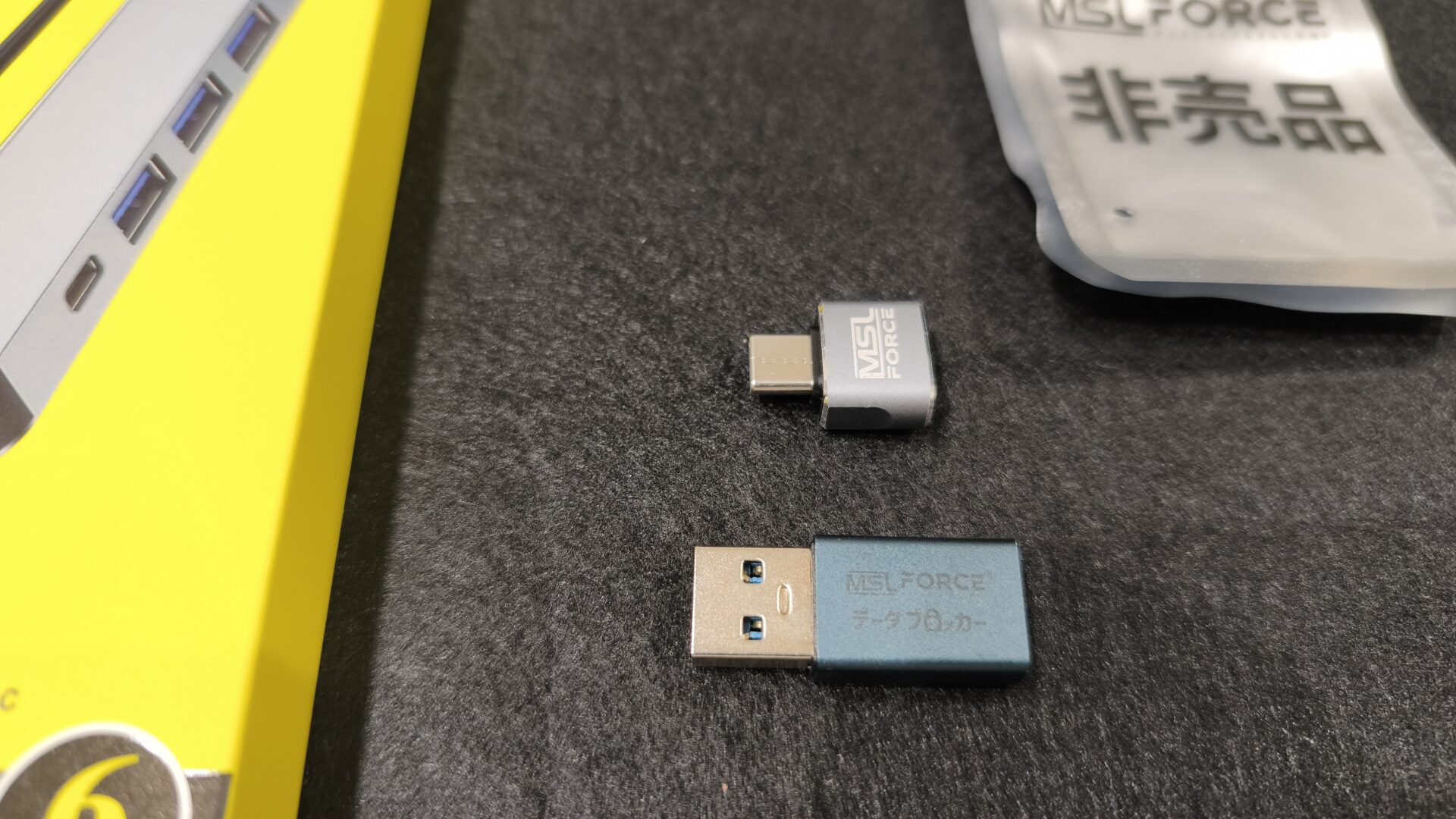 お店から届いた変換アダプタ2個。銀色のおまけと、データブロッカー刻印の青緑色
